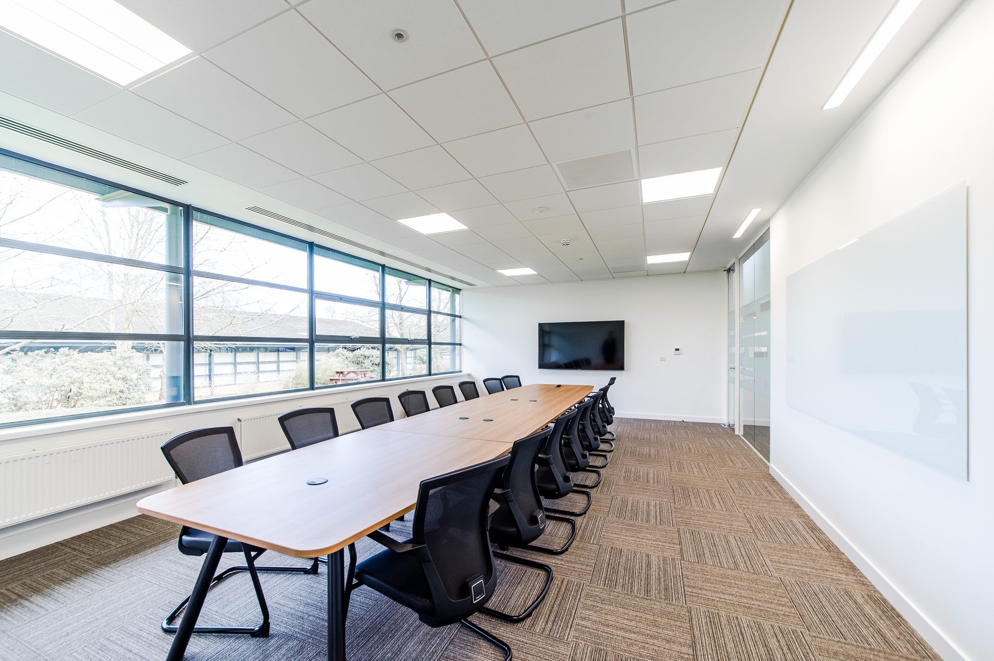 Long boardroom with oak table and woodland view
