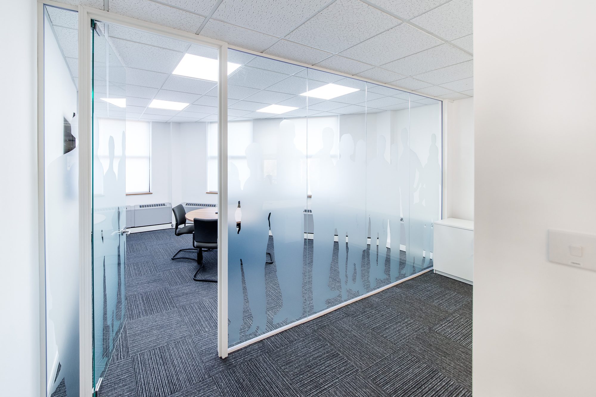 Smaller meeting room with silhouette manifestation pattern on the glass partition