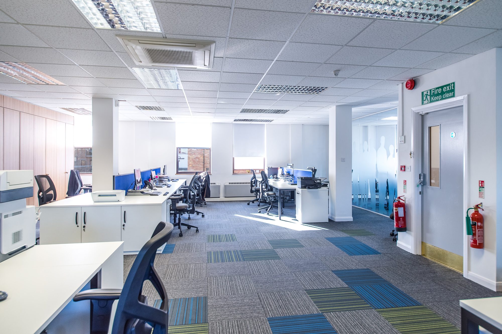 Bright open-plan office after refurbishment, with new glazed partitions to private offices