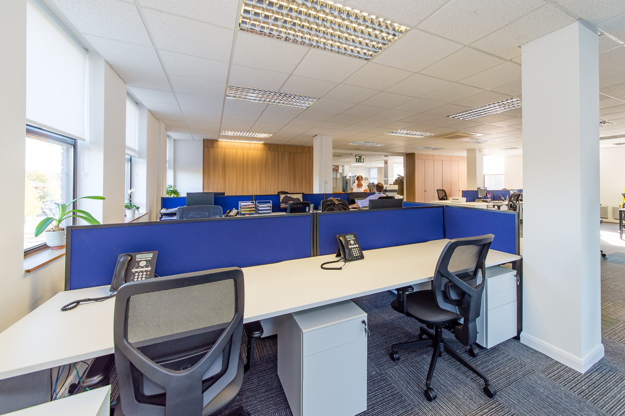 Motion blur of someone walking down the central aisle past new desks