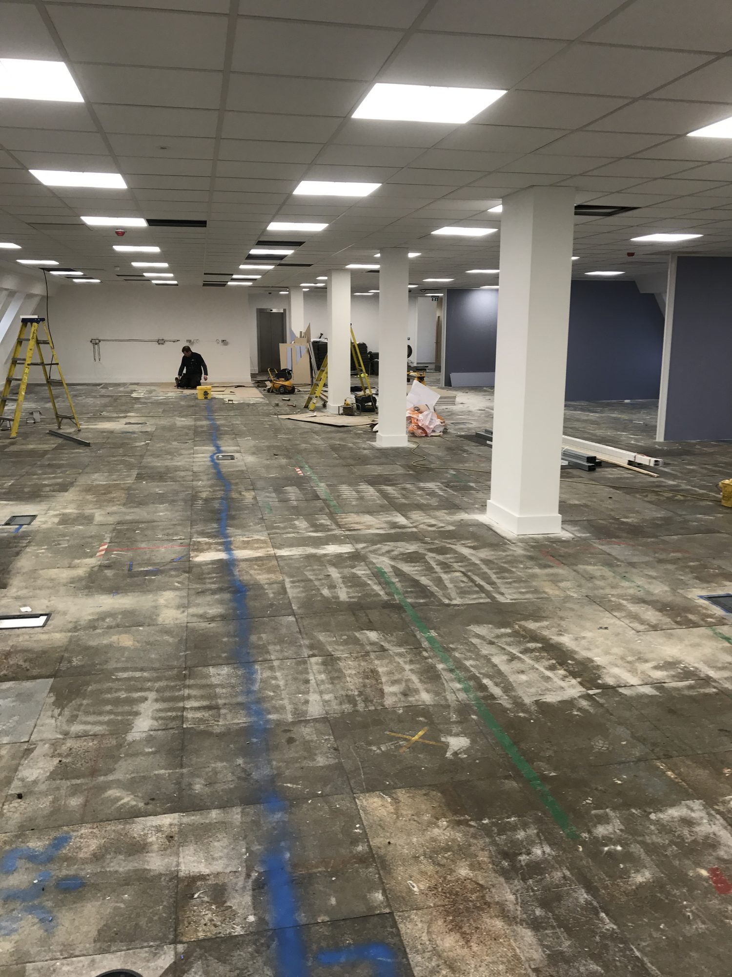 Looking down the floor mid-build with cable channels visible and workers on site
