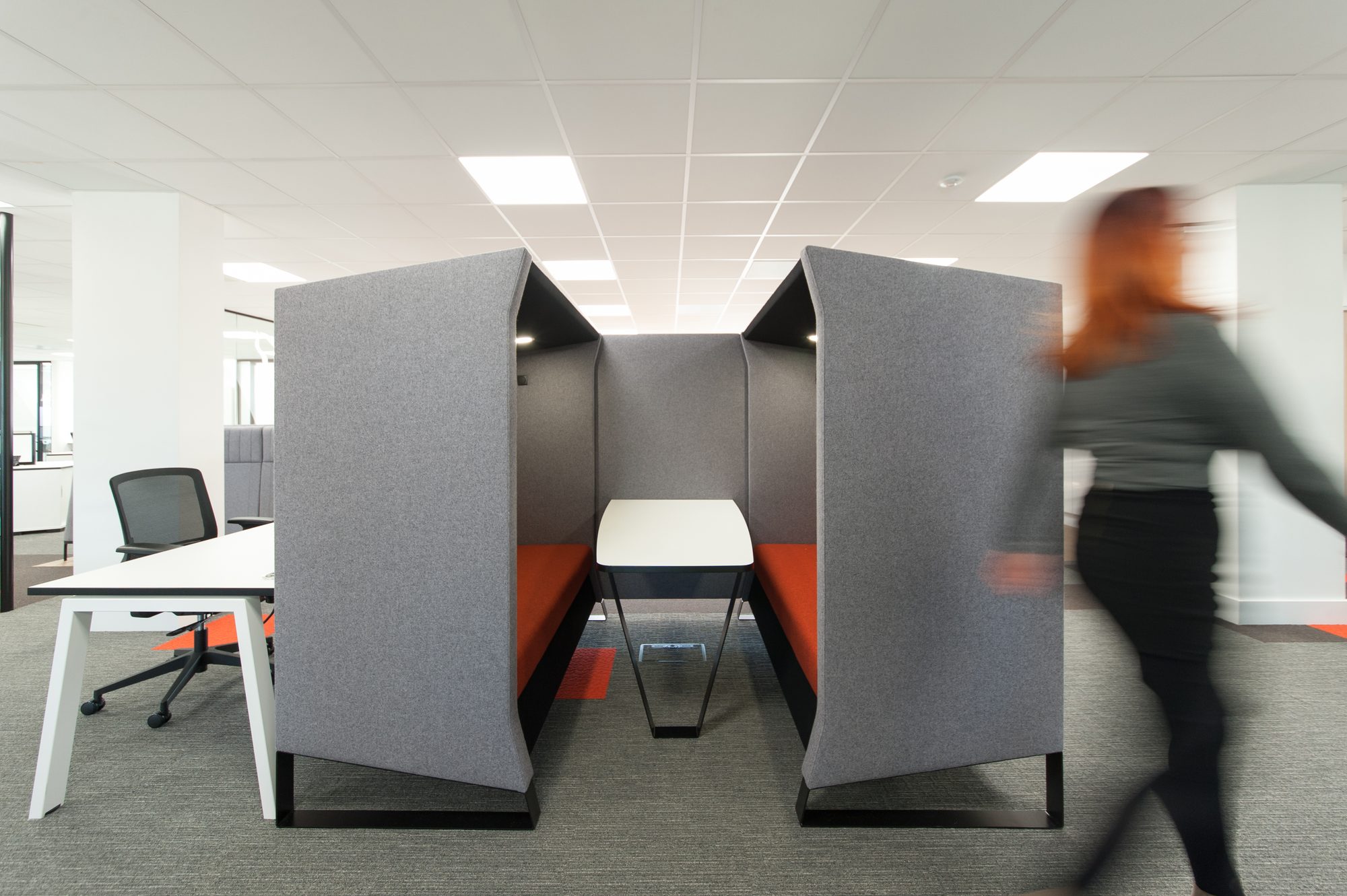 Acoustic focus pods with grey high-back walls and orange interior