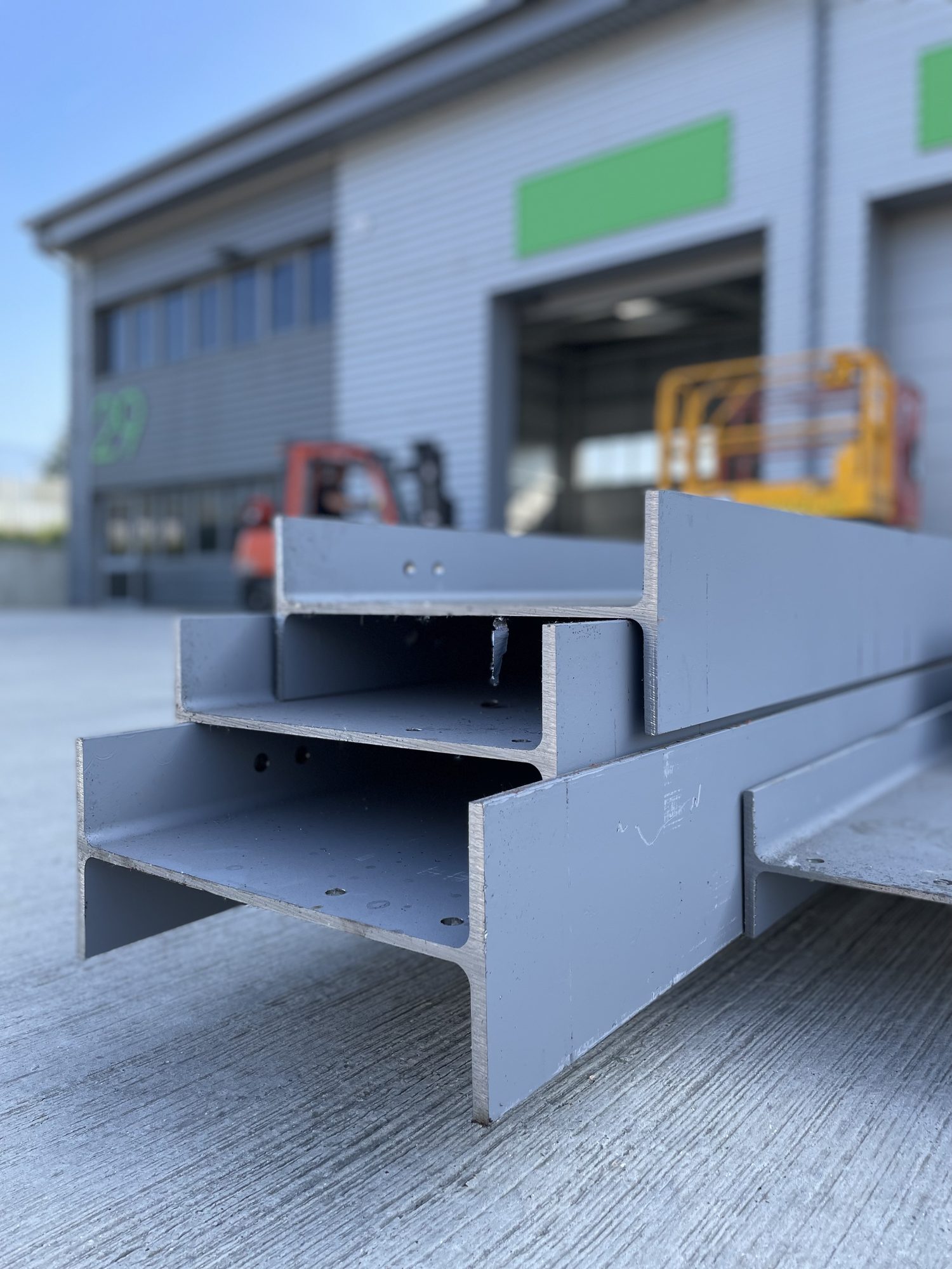 Bespoke fabricated steel mezzanine beams stacked outside the warehouse ready to be lifted in