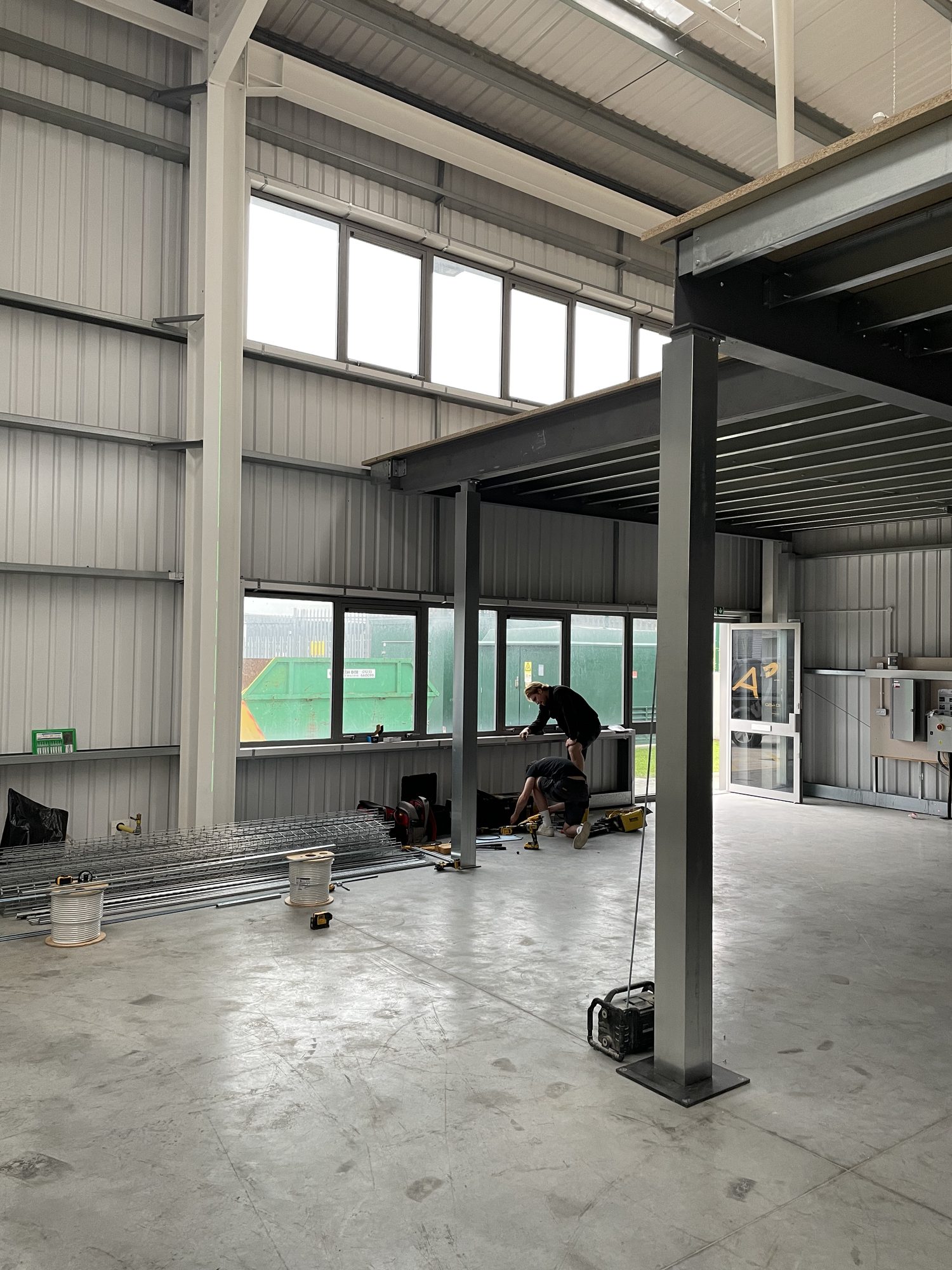 Structural mezzanine frame installed inside the warehouse with steel columns and primary beams