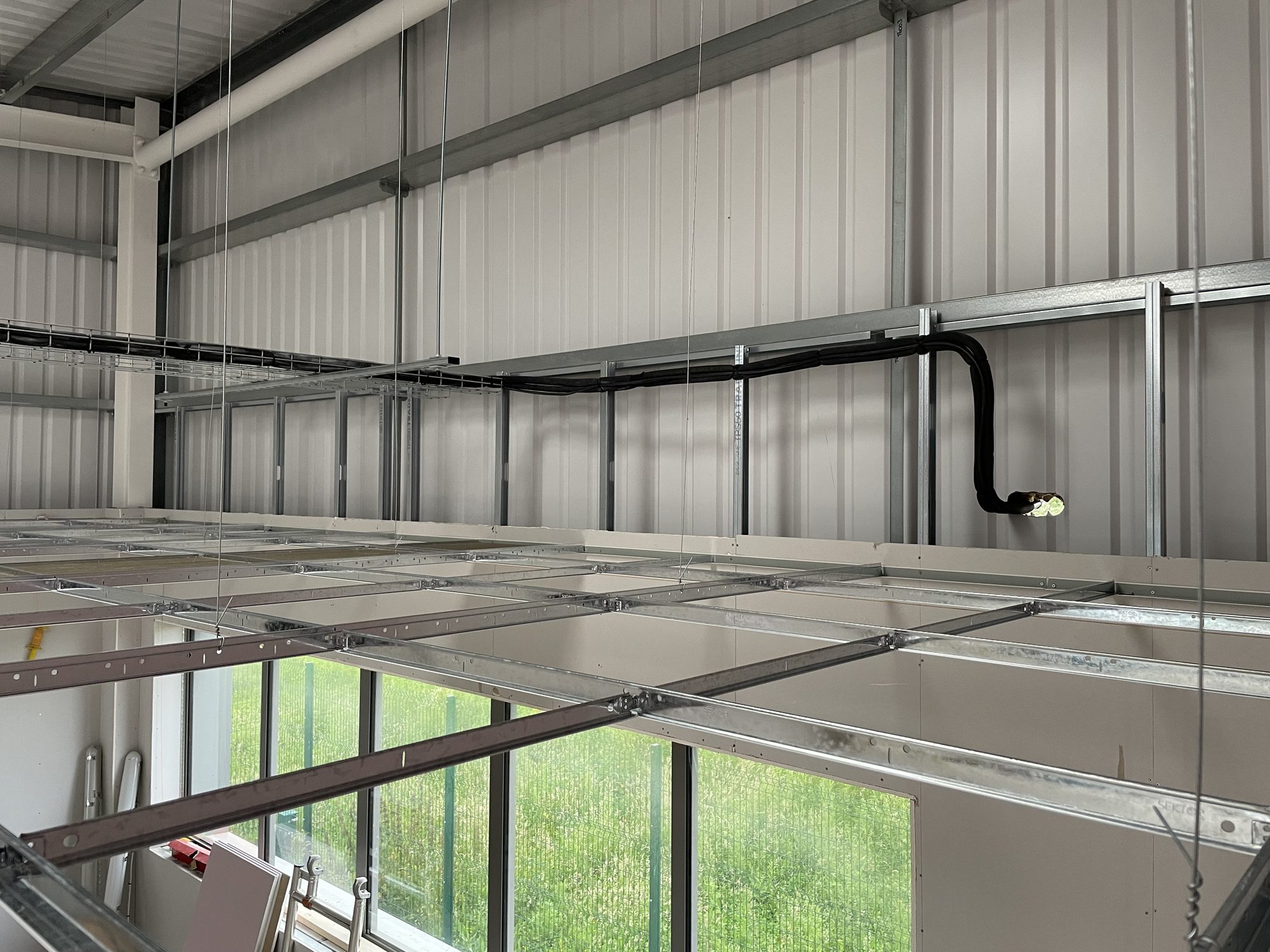 Suspended ceiling grid and metal stud partitions framed out below the mezzanine