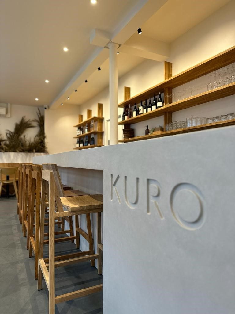 Closer look at the debossed Kuro wordmark and oak stools