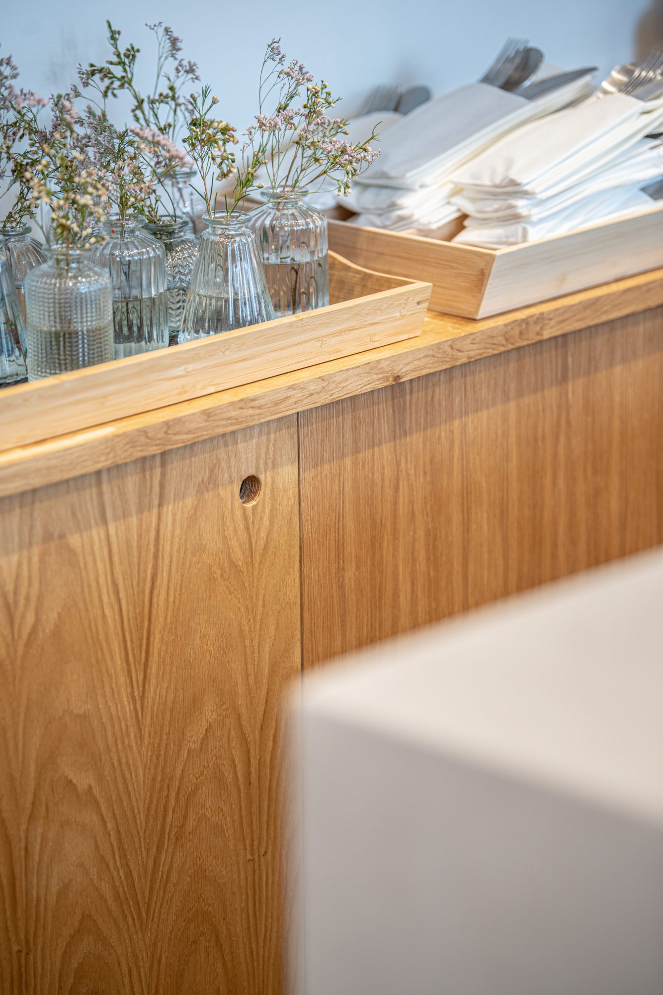 Oak counter detail with bamboo trays, glassware and napkins