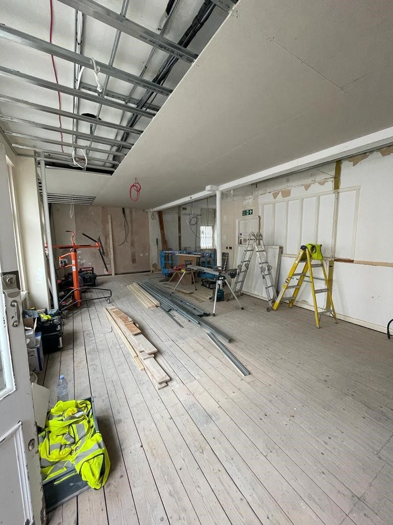 Mid-build with ceiling stripped back to grid and plywood subfloor laid