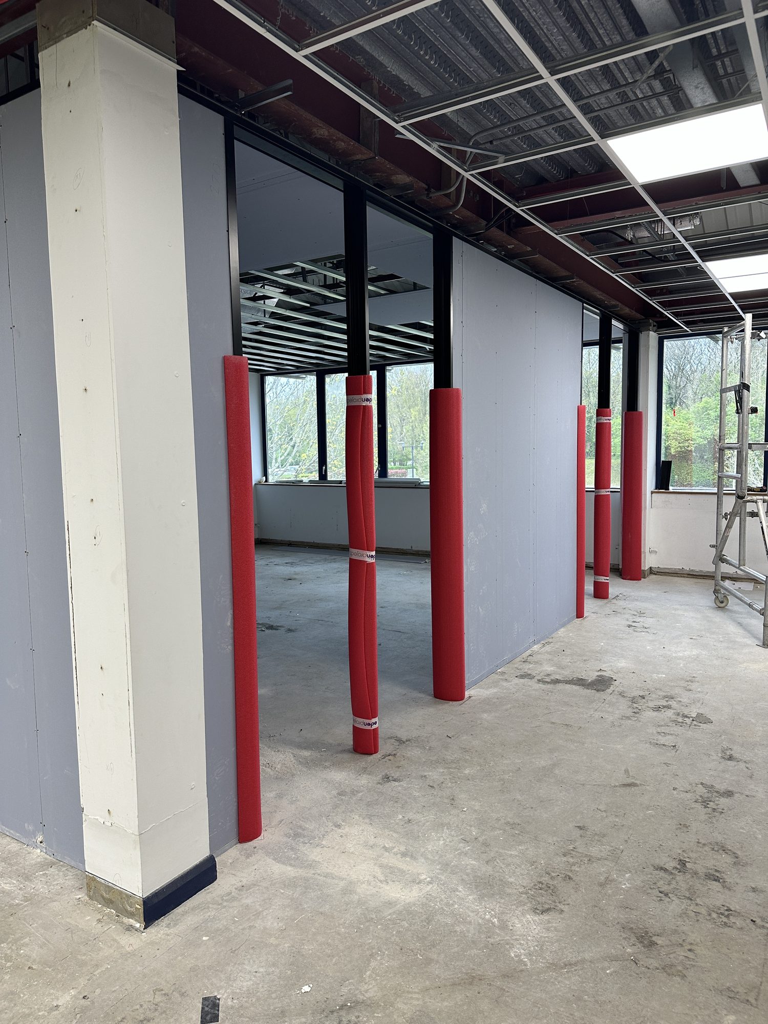 Stud and glazed partitioning starting to take shape around protected columns
