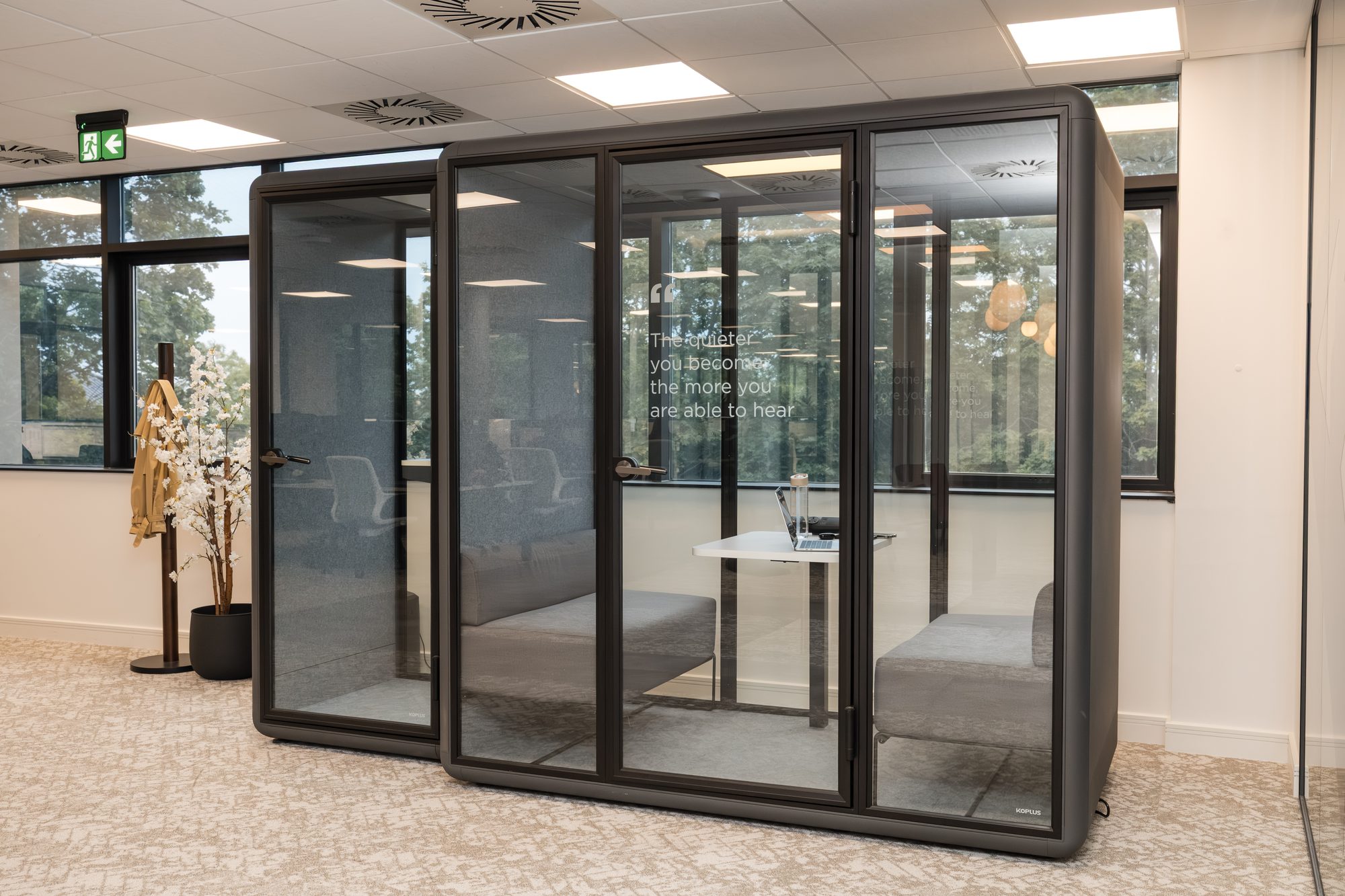 Row of dark-framed Koplus acoustic meeting pods with frosted manifestations