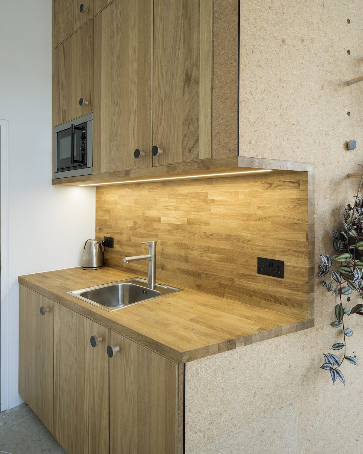 Bespoke oak kitchenette with worktop-lit splashback