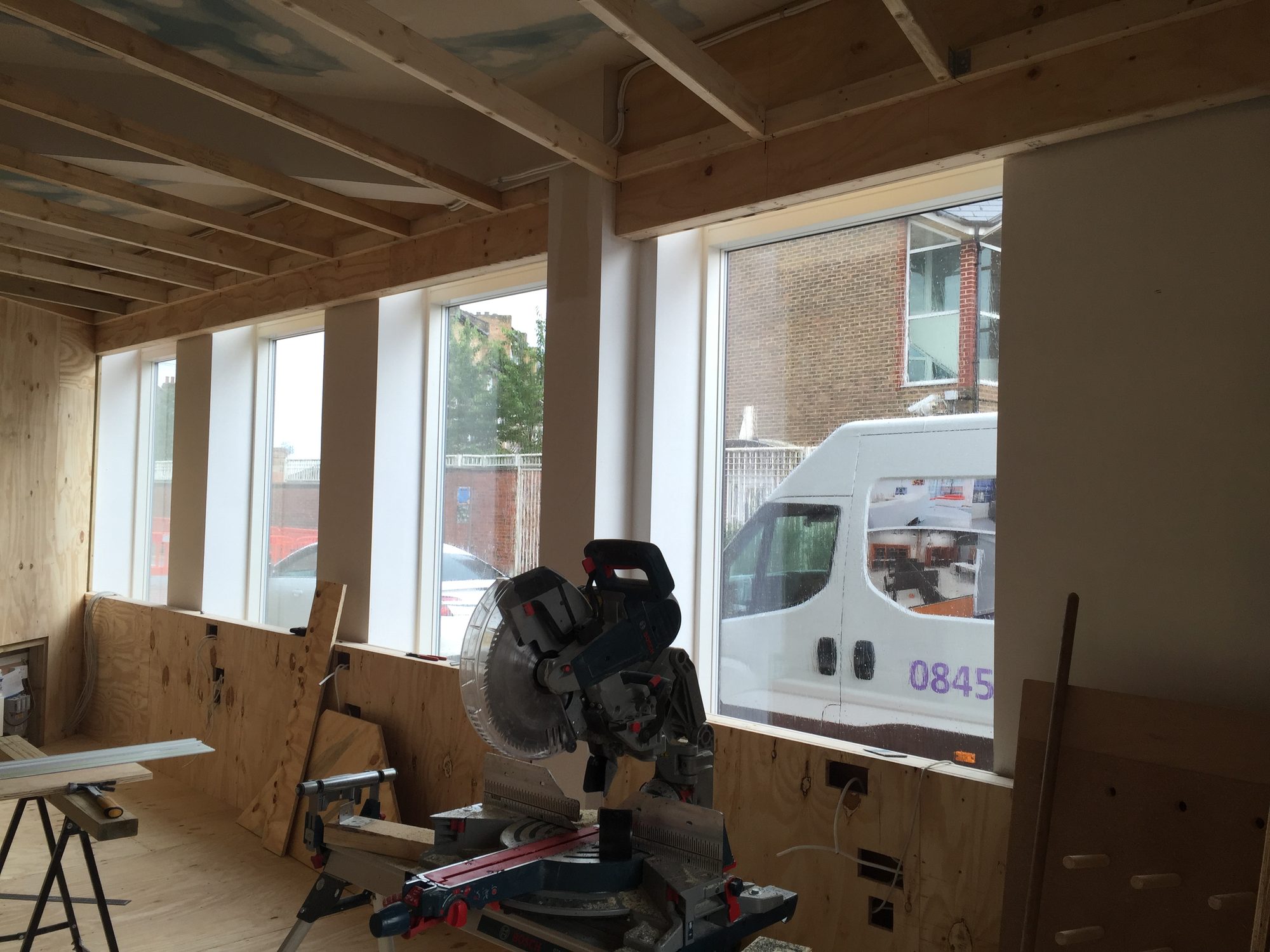 Window reveals being formed in plywood with mitre saw on site